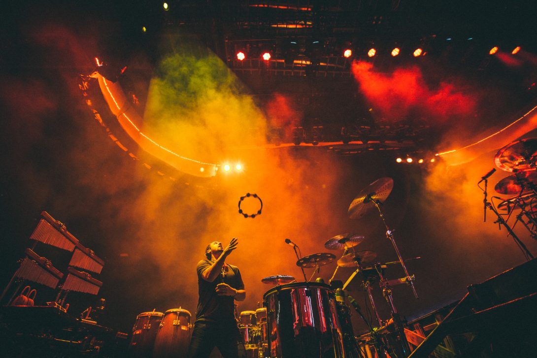 Daniel de los Reyes commanding the stage beneath orange and red concert lights